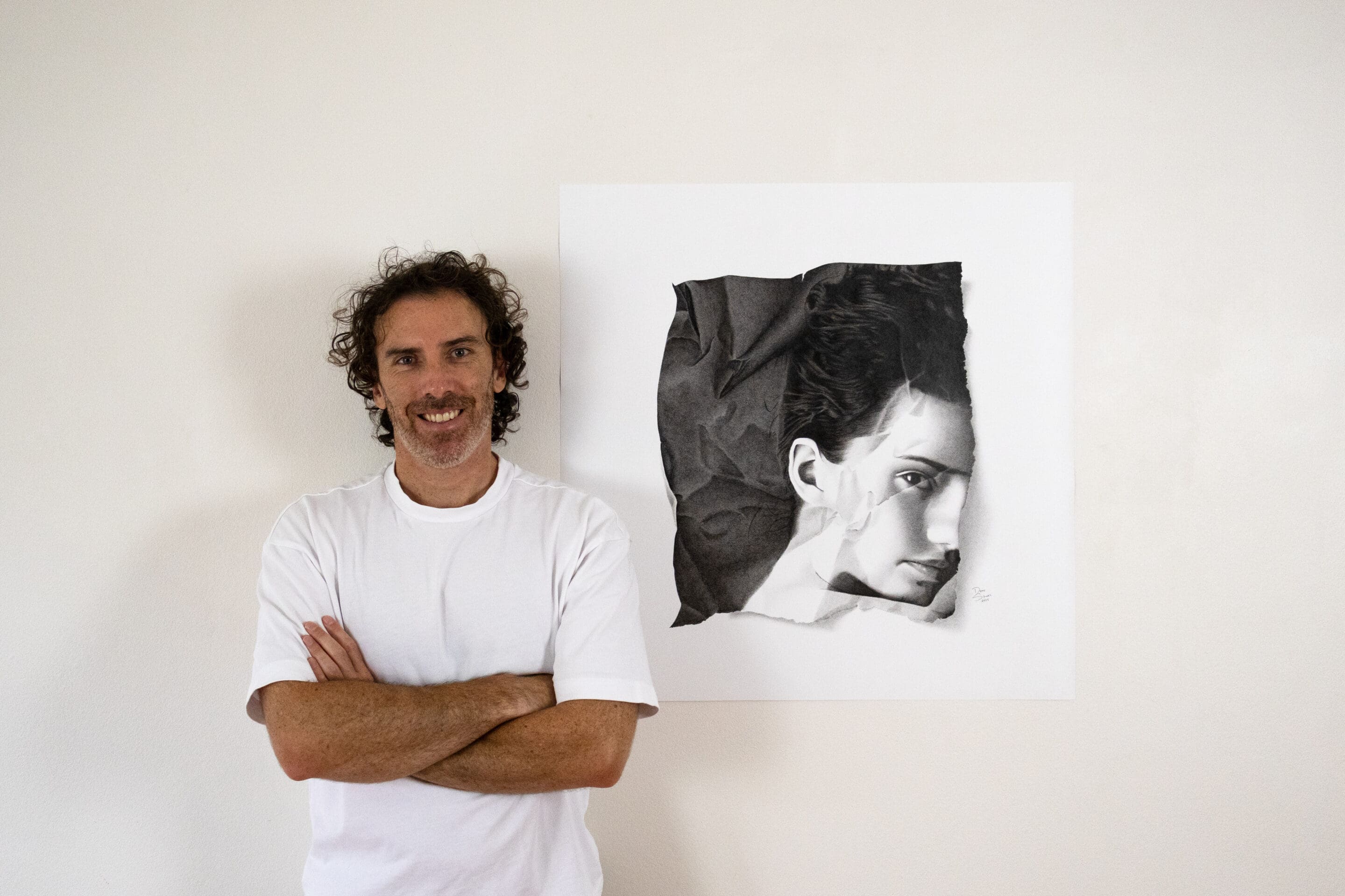 Artist Dean Spinks pictured with original Copic marker artwork, square-format photorealism portrait from Shattered Vanity.